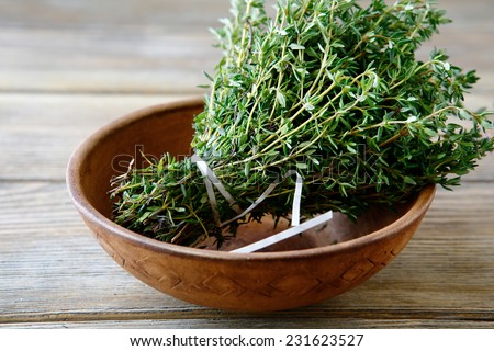 Green thyme in a bowl on boards, close up