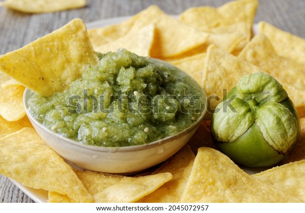 Green tomatillo salsa (salsa verde cruda) with\
corn tortilla chips\
nachos.