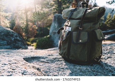 Green touristic backpack of anonymous hiker left alone on stony ground in Yosemite National Park in America in sunny day - Powered by Shutterstock