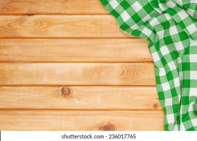 Green Towel Over Wooden Kitchen Table. View From Above With Copy Space