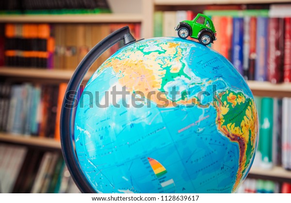 green toy car on\
globe