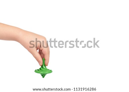 Green toy giroscope with kid hand, isolated on white background. copy space template.