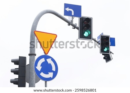 Green traffic light at an intersection on a cloudy day. Road safety and transportation control signal. Urban street scene guiding vehicles and pedestrians.