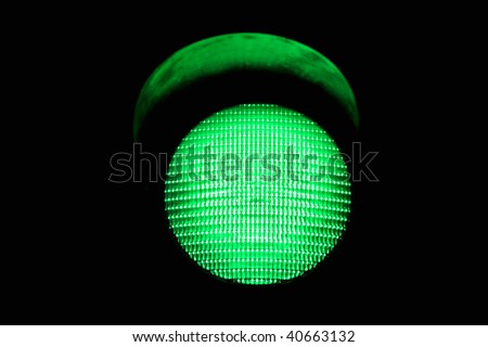 green traffic light, isolated on black background