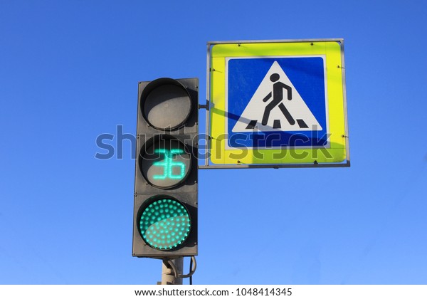 Green Traffic Light with Timer and Pedestrian\
Crosswalk Stop Signal on Blue Sky Empty Background. City Street\
Traffic Light Showing 36 Seconds, Crossing Street Caution, Safety\
and Warning Concept.