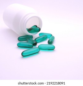 
Green Transparent Soft Gel Pill Capsules For Health Spill Out, Scatter From White Plastic Bottle  On Isolated White Background.
Healthcare Medicine, Lifestyle, Pharmaceutical Painkiller Concept.