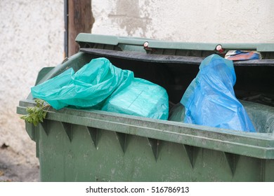 Green Trash Dumpster Full Of Garbage. Close Up.