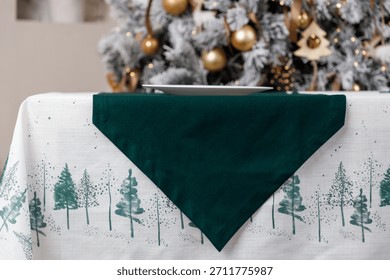 Green triangle table runner on forest print Christmas tablecloth