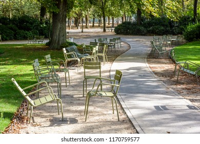 Green Typical Metal Lawn Chairs Scattered Alongside An Alley Of The Luxembourg Garden In Paris, France, By A Sunny Summer Morning.