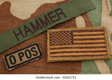 Green US Flag, Name Tag And Blood Type Patch On Woodland Camo Background