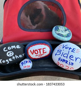 Green Valley, AZ / USA - October 20, 2020:  Pet Stroller With Cat Inside And Painted Rocks For Election:  Come Together With Peace Sign; Biden 2020; VOTE; Peace With Dove; And Vote Biden Harris 2020