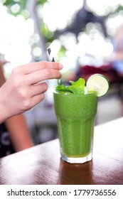 Green vegan healthy smoothie with mint in glass in female hands. Clean detox eating. Weight loss concept - Shutterstock ID 1779736556