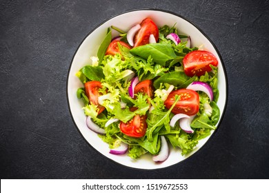 Green vegan salad from green leaves mix and vegetables. Top view on black. - Shutterstock ID 1519672553