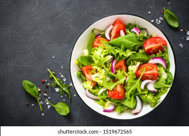 Green vegan salad from green leaves mix and vegetables. Top view on black. - Shutterstock ID 1519672565