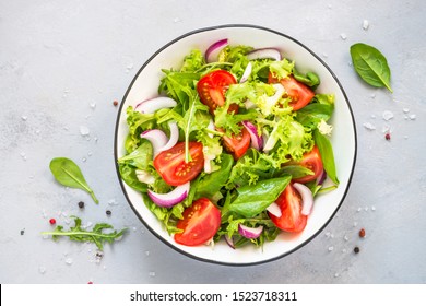 Green vegan salad from green leaves mix and vegetables. Top view on gray stone table. - Shutterstock ID 1523718311