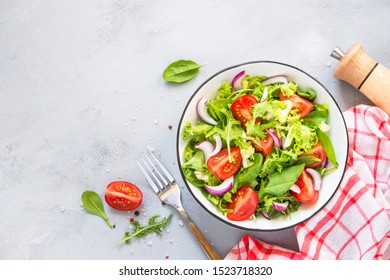 Green vegan salad from green leaves mix and vegetables. Top view on gray stone table. - Shutterstock ID 1523718320