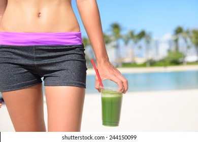 Green vegetable smoothie. Woman living healthy lifestyle drinking vegetable smoothies after fitness running workout on summer day. Beautiful fit sports model eating healthy.