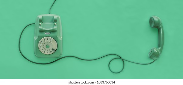 A green vintage dial telephone with green background.
