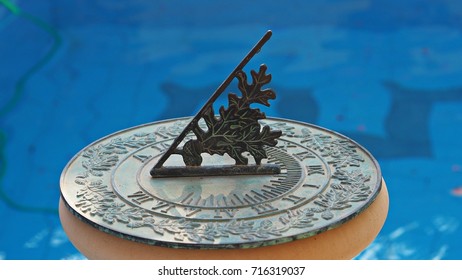 A Green Vintage Sun Dial Or Sun Clock Above Swimming Pool. 