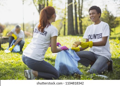 Green volunteering. Optimistic two volunteers holding garbage bag and communicating