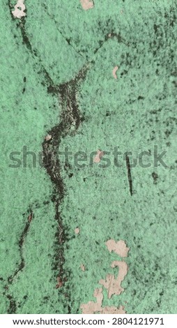 a green wall whose paint is peeling