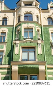 Green washed facade of the 19th century building with bear sculptures on the oriel windows and images of oak branches with acorns, squirrels and birds in Vyborg, Russia