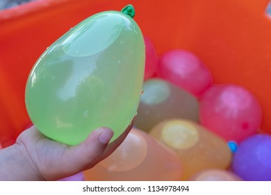 Green Water Balloon In Child Hands 