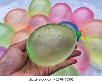 Green Water Balloon On Hand With Pastel Tone Water Balloons Background In Summer For Outside Family Game