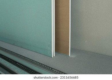 Green waterproof drywall or greenboard. Paper faced gypsum board, moisture proof plasterboard building material. Panel used in construction of interior walls and ceilings.