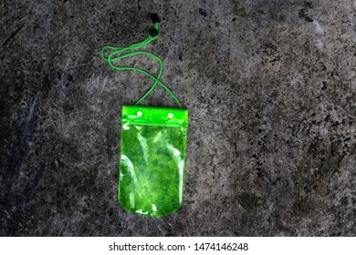 Green Waterproof Mobile Phone Case On Texture Background.PVC Zip Lock Bag Protect Mobile Phone Or Important Items From Water.Concept For Songkran Water Festival In Thailand.