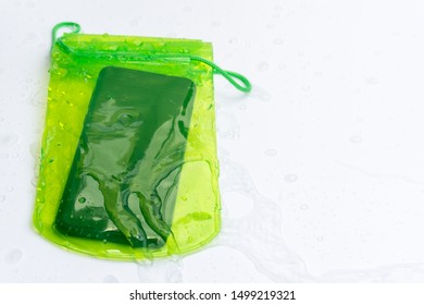 Green Waterproof Mobile Phone Case With Water Droplets On White Background.PVC Zip Lock Bag Protect Mobile Phone Or Important Items From Water.Concept For Songkran Water Festival In Thailand.