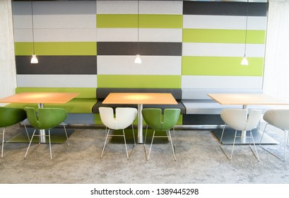 green and white chairs and tables in modern cafeteria