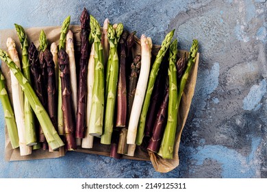 Green, white and purple asparagus on a kitchen background - Shutterstock ID 2149125311