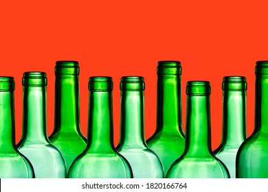 Green Wine Bottle. Empty Glass Isolated On Red. Set Of Blank No Label Wine Bottle In A Row. Winery Shelf Texture. Alcohol Background. Shiny Transparent Vibrant Color Panoramic View.