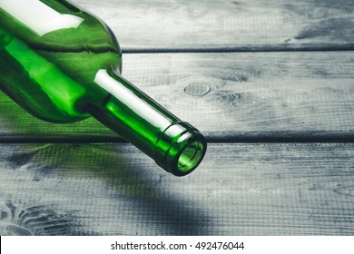 Green wine bottle on black grunge wooden table background.
