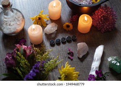 A Green Witch Altar Space With Flowers, Cauldron, Candles, Crystals, And Salt.