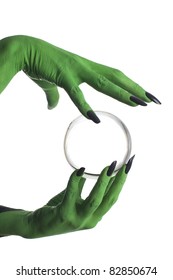 Green witch's hand holding crystal ball, white background.