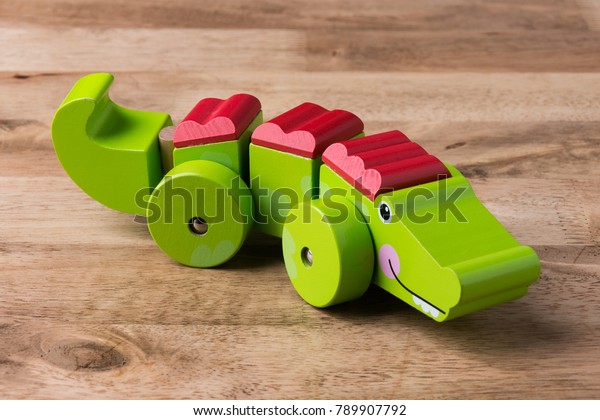 Green wood crocodile toy\
on wood table