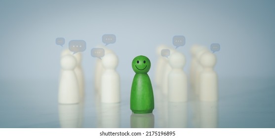 Green wood figure with happy face standing out from the crowd of different people. Individuality, Introvert, Not care when someone is talking, Unique human shape, Leadership,  Human resource.  - Shutterstock ID 2175196895