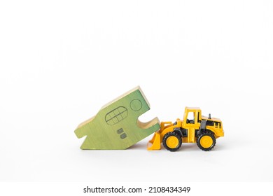 Green Wooden House Model With Front Loader Truck Isolate On White Background, Clearance Sale, Property And Real Estate Business Industry Concept