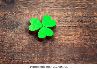 Green Wooden Shamrock Laying On A Wooden Board. St. Patrick's Day. Irish Culture.