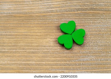 Green Wooden Shamrock Laying On A Wooden Board. St. Patrick's Day. Irish Culture.