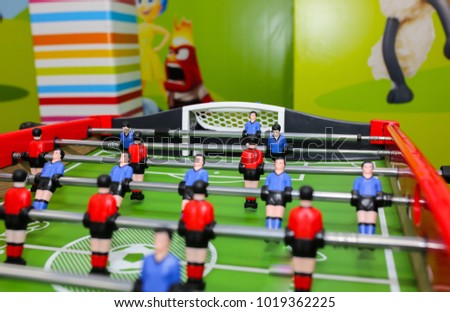 Green wooden table football in the children room. Foosball in children centre with colorful walls on background. Play entertainment centre.