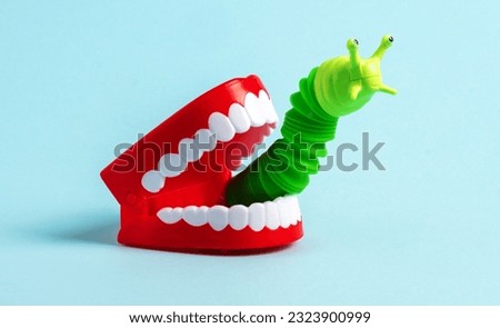 Green worm crawls out of  human jaw. Halloween greeting card. Bad breath concept.  Eating insects concept.