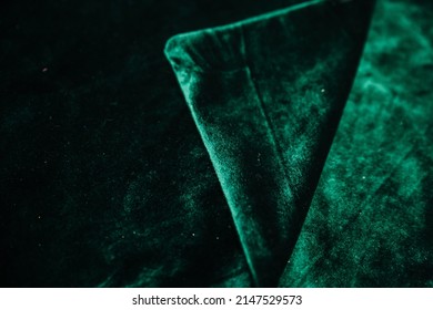 A Green, Wrinkled Fabric Lies In Folds On A Draped Table. Emerald Velvet. Texture