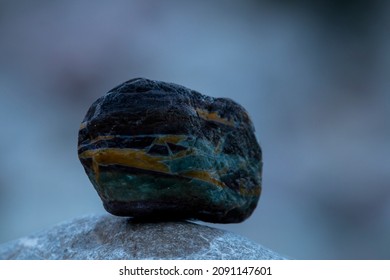 A Green, Yellow And Black River Stone