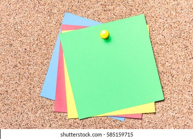 Green, yellow,red and blue notes pined to cork board. Empty reminder cards. - Shutterstock ID 585159715