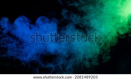 Green-blue smoke in neon light on black background.