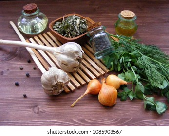 greenery  : fresh parsley and dill, onion, garlic, olive oil in glass, dry spices in bowl and juniper berries are ideal for game or rustic cuisine on wooden table - Powered by Shutterstock