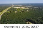 Greenery highway interstate 10 (I-10) with lush green Loblolly pine trees Pinus taeda to horizontal line, natural forestry site in Louisiana near Greenwood rest area. Aerial freeway rest stop in USA